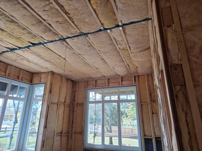 Insulation batts fitted into timber wall studs before plasterboard install